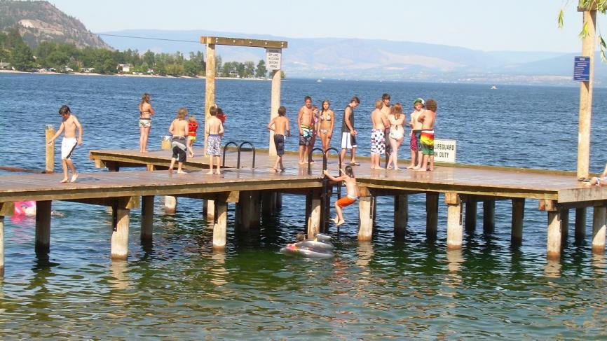 People standing on lakeside dock.