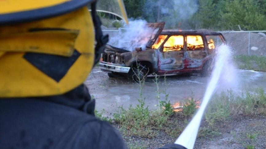 Firefighter putting out burning car.