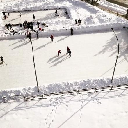 People playing on an outdoor ice rink.