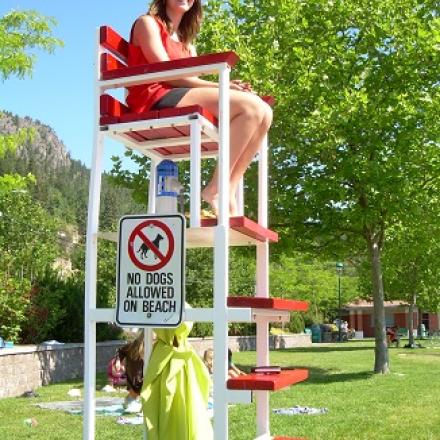 Lifegueard sitting on lifeguard chair.