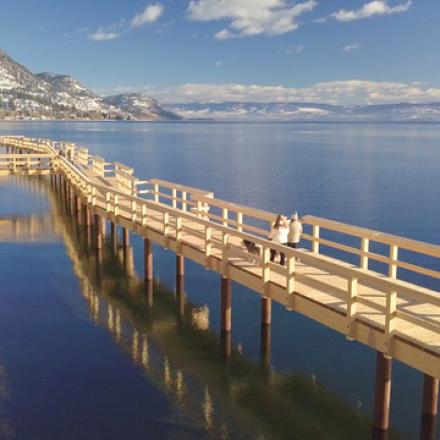 Pier over water. There is a rocky shore next to the pier.