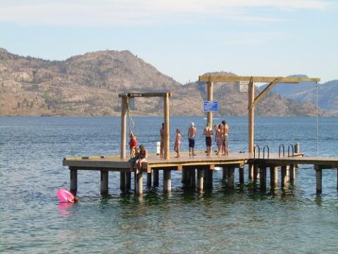 Group of people standing on a dock near the water.