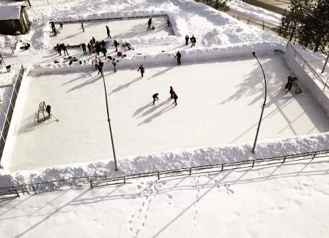 People playing on an outdoor ice rink.