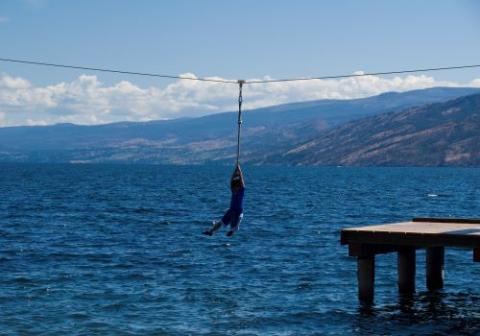 Person on zipline going over water.