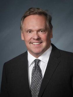 Councillor Dave Collins headshot. There is a smiling man in a suit and tie.