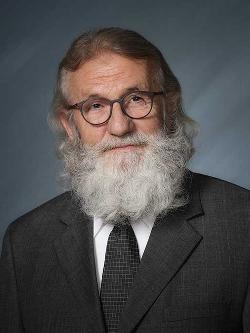 Deputy Mayor Keith Thorn headshot. There is a smiling bearded man in a suit wearing glasses.